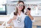 Woman in kitchen looking at surveys on her phone